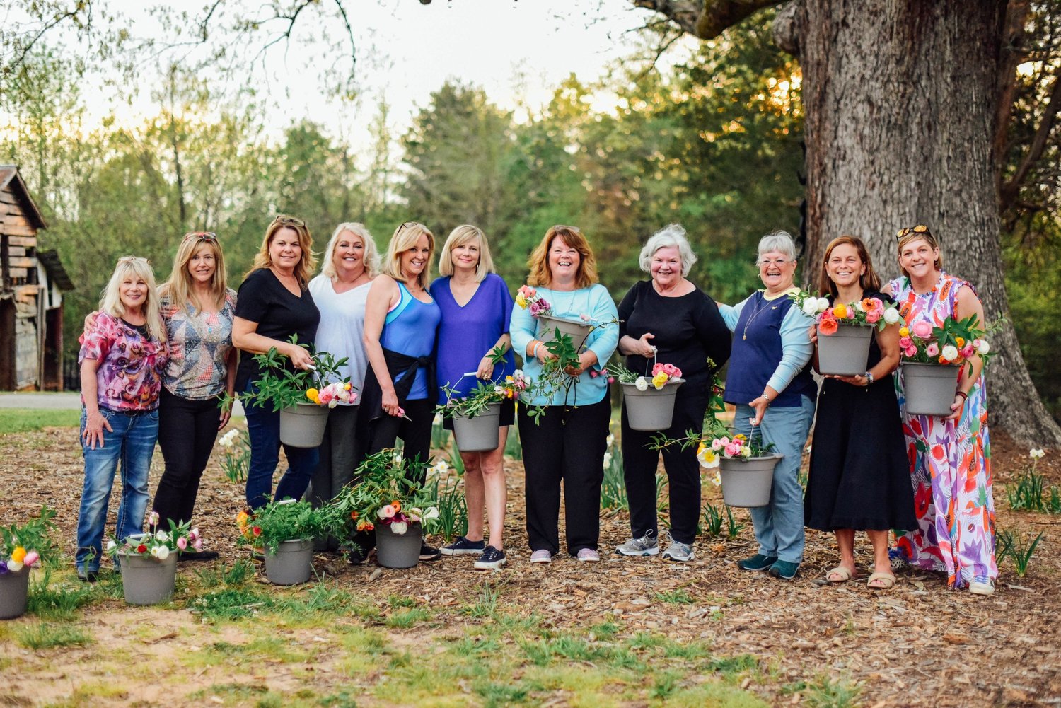 Guests gathered around a table arranging flowers outdoors